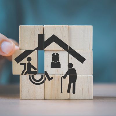 senior woman's hand completed house shape icon with nurse, elder