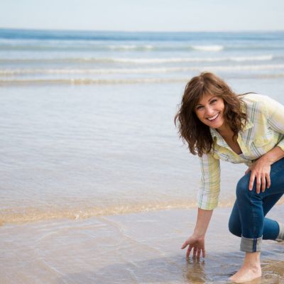 Beautiful middle aged woman having fun on the beach