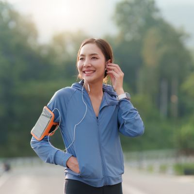 Healthy Asian woman is jogging outdoor. Fitness girl running. Female exercising at outdoor park